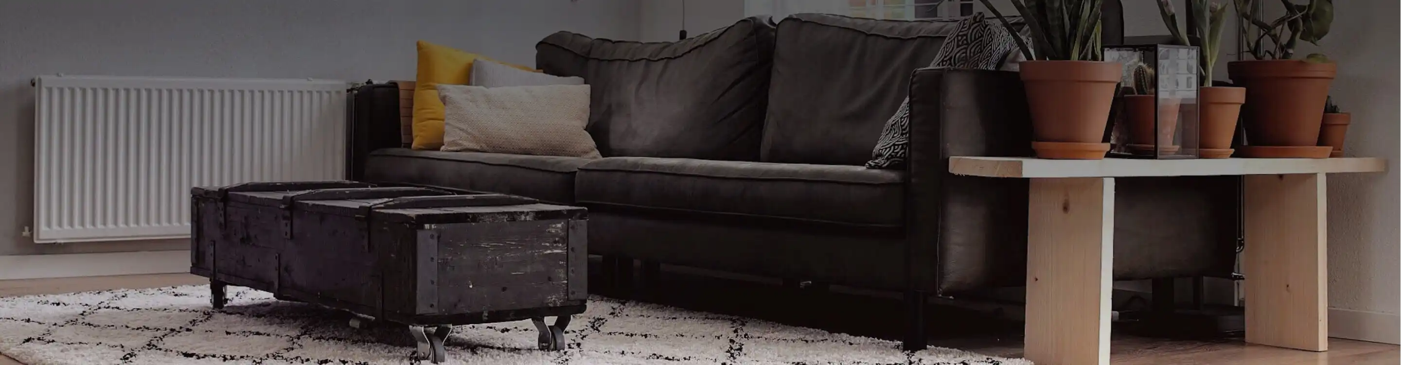 living room with leather couch and neutral area rug