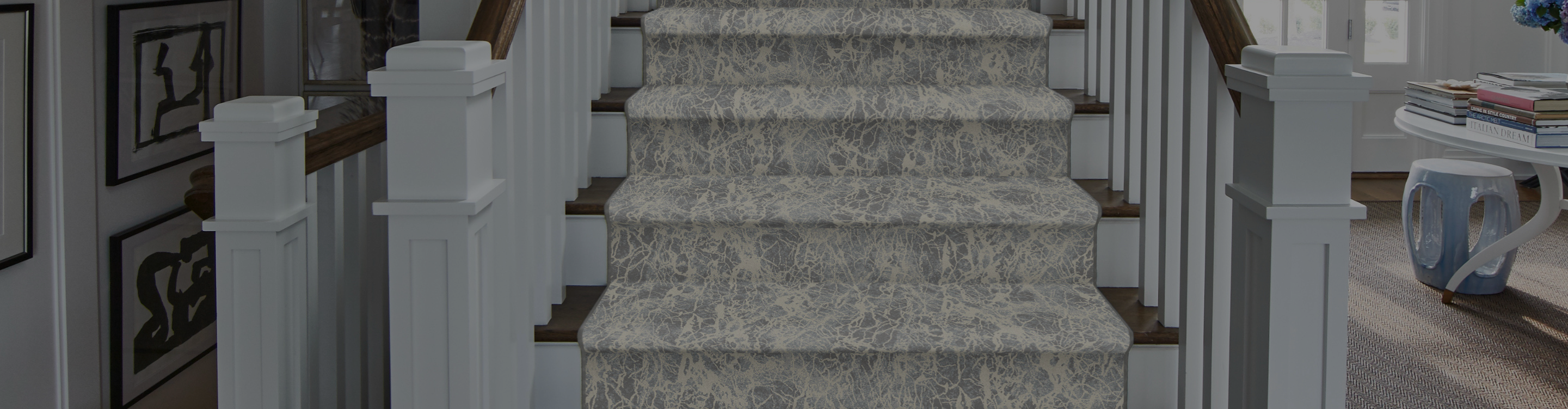 White patterned carpet stair runner on hardwood stairs.